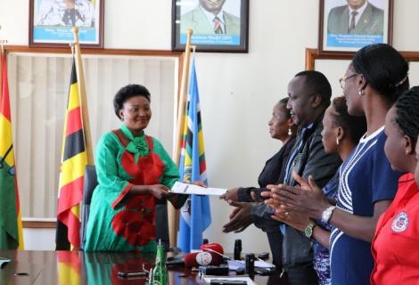 Tax Justice Alliance members presenting their petition to the former opposition leader in Parliament, the Honorable Winnie Kizza