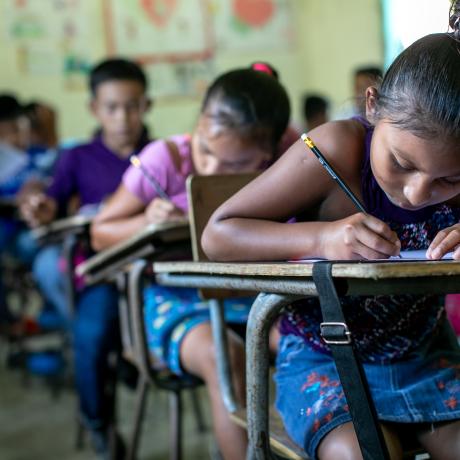 Students at the San Juan Villa Nueva School excitedly write their messages to their sponsors in the UK during Action Aid's annual message collection, 